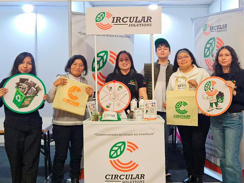 Equipo de Circular Solutions en un stand con material de reciclaje